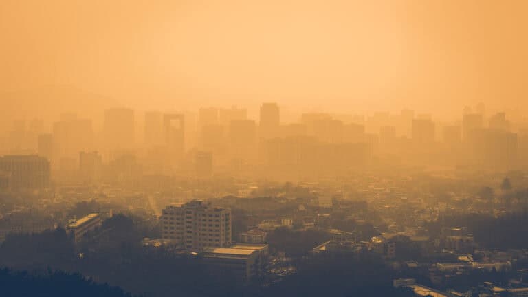 Hazy city skyline with smog and pollution, demonstrating air quality concerns, focus on innovative air purification, Circul-Aire air filtration solutions, improving indoor air quality and environmental health.